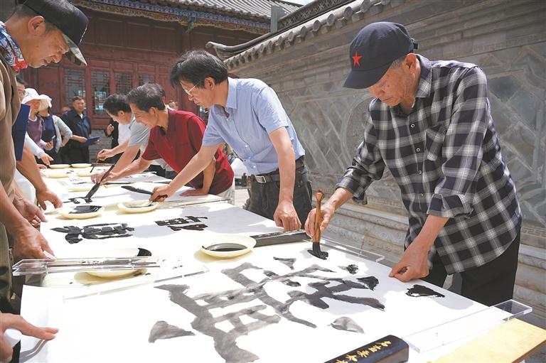 书法家在陆良爨体书法艺术馆外进行创作。 陈思远 摄