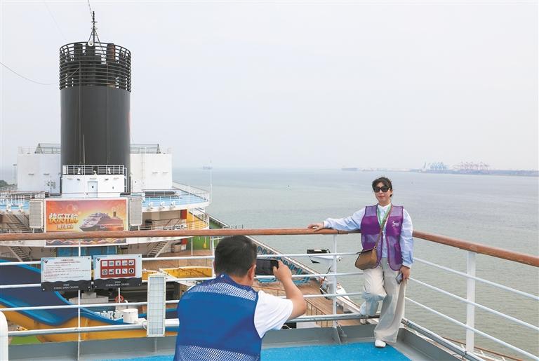 旅客在“理想号”邮轮上拍照打卡。新华社发