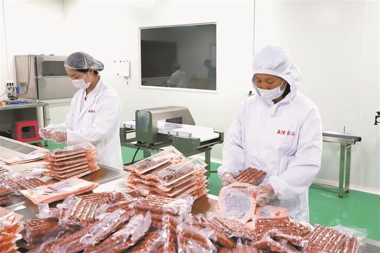 工人分装腊肠成品。 潘田 摄